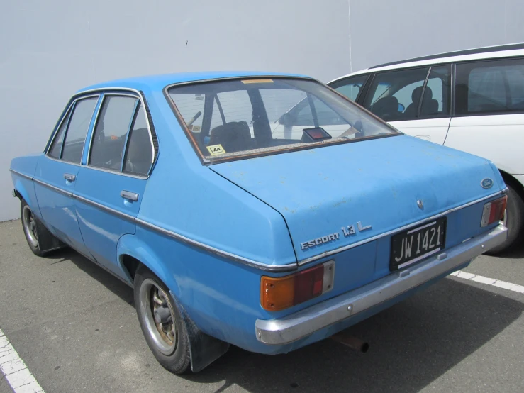 an older blue station wagon in parking lot
