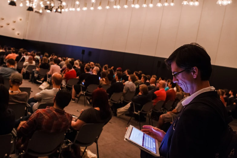 man showing tablet to audience at a meeting