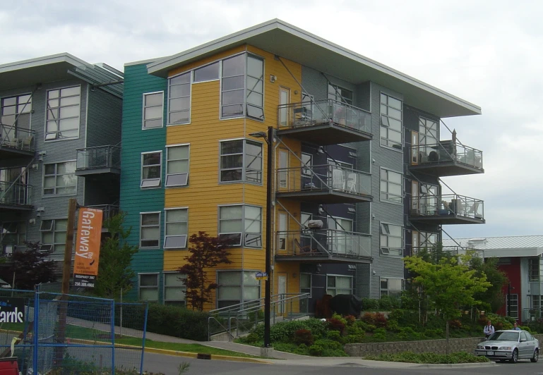 a multi - colored apartment building on a corner with lots of windows