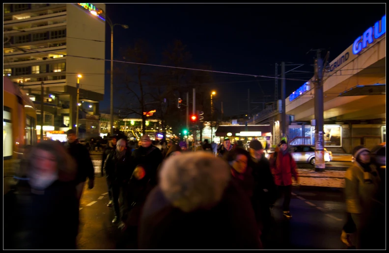 a crowd of people standing on the side of a street