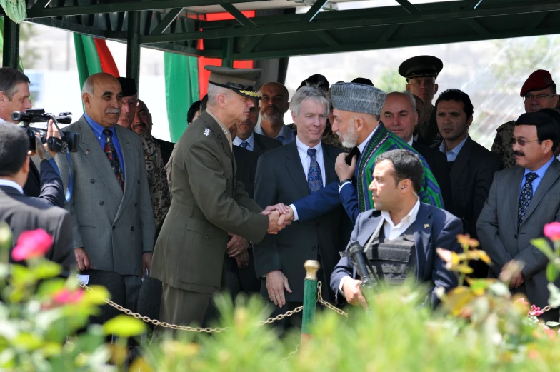 the two men shake hands over a rope at the end of the ceremony