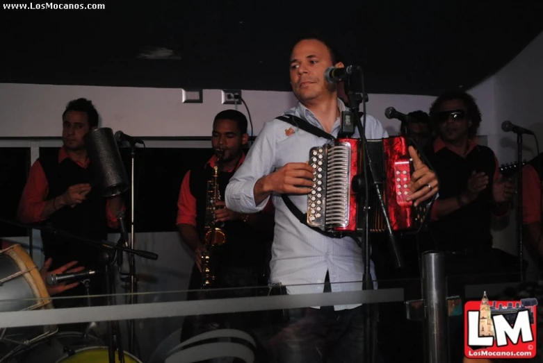 a man with a band playing the music at a karaoke bar