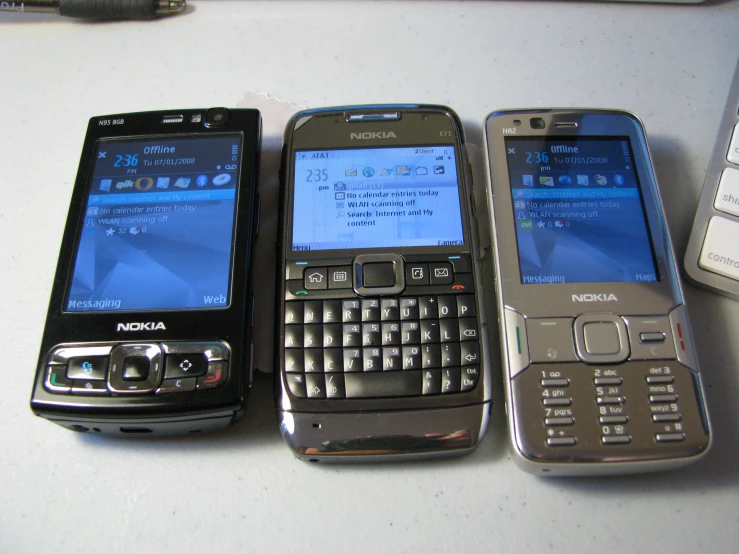 three cell phones lined up together on the table