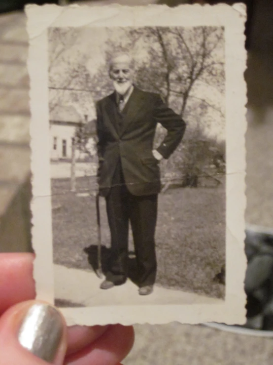 a man in a suit and tie holding a picture of himself