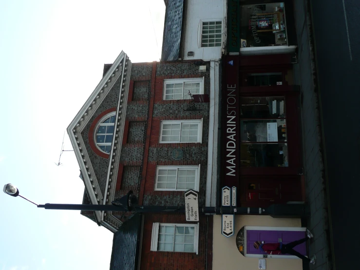 a tall brick building next to two businesses