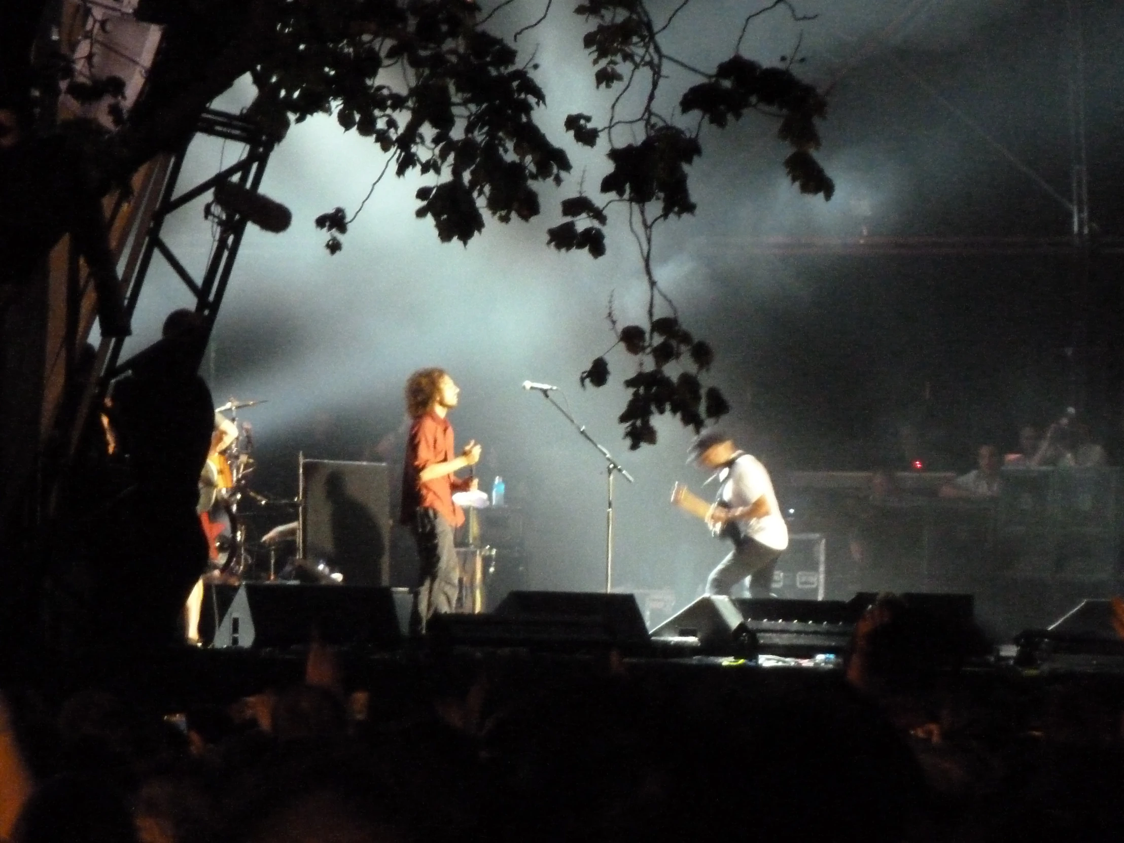 three band members on stage at an outdoor concert