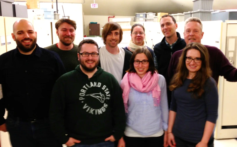 group of people posing together in front of cabinets