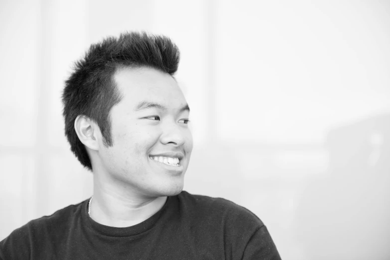 an asian man wearing a black shirt is smiling