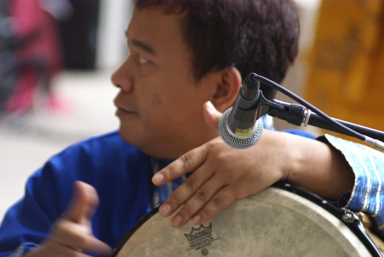 a young man is playing the congrenious tambour