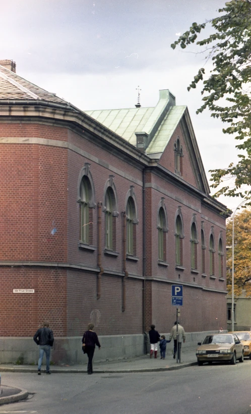 people are standing outside of an old brick building