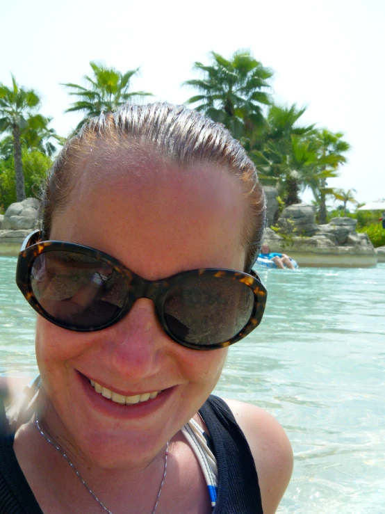 woman wearing large sun glasses at the edge of water