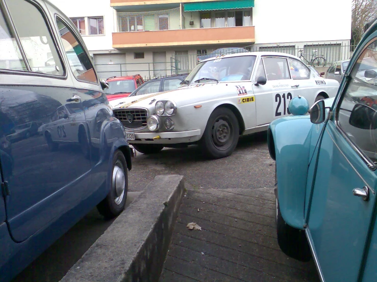 an old blue and white car is being pulled by another old blue and white car