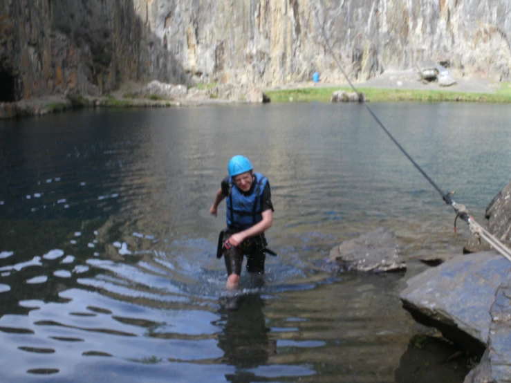 a man wearing water gear walking into a lake