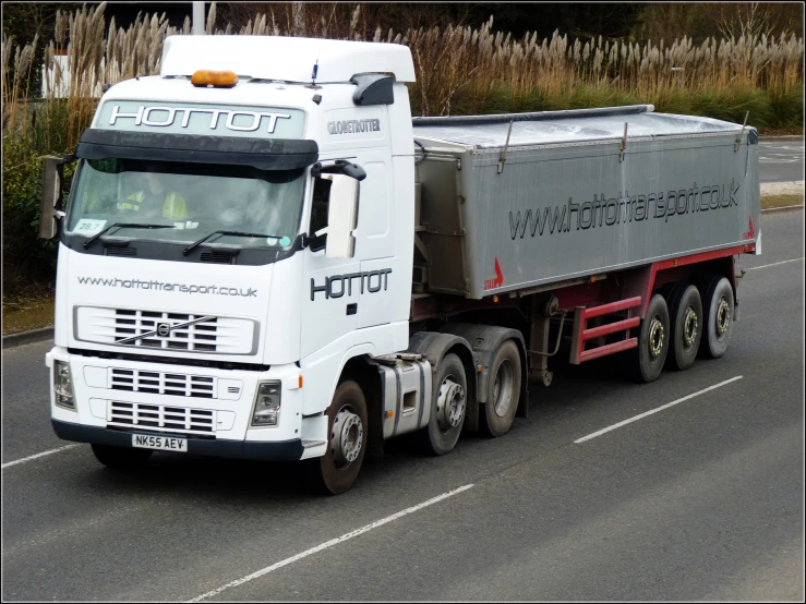 an truck is driving down the road with other trucks