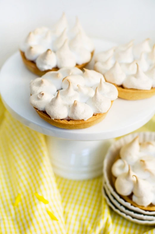 a white pedestal topped with mini desserts covered in frosting