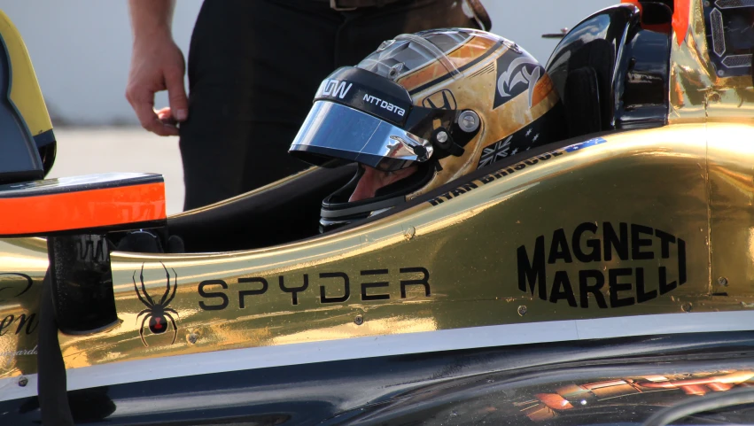 the helmet sits atop the vehicle's shiny gold finish