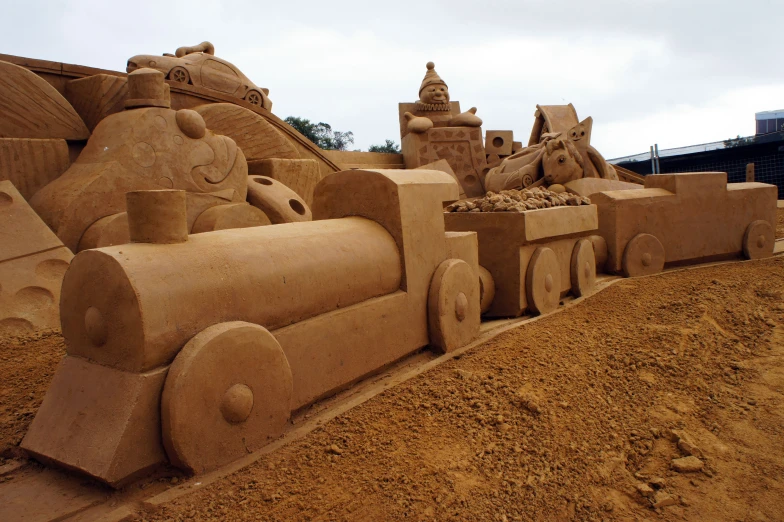 a sand model of a train next to sand sculptures