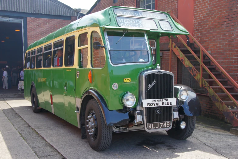 a vintage passenger bus parked in front of a building