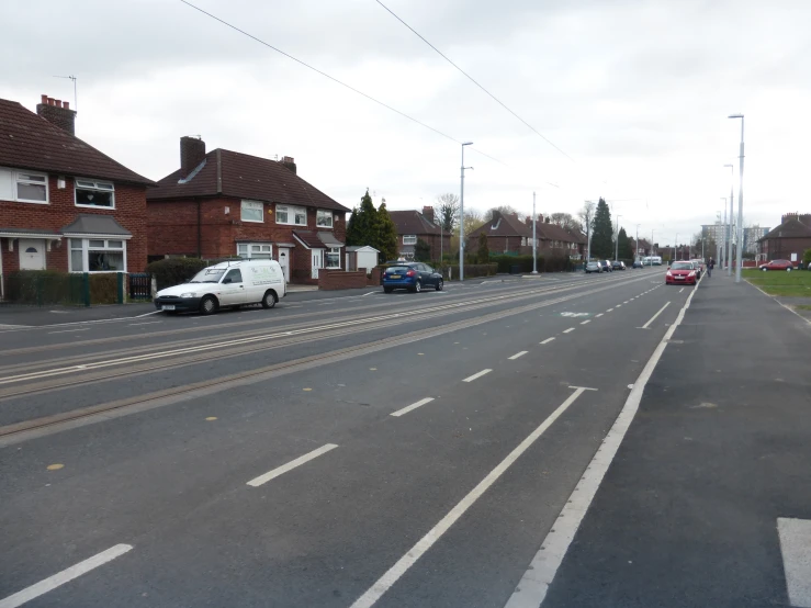 a car drives down the road near some houses