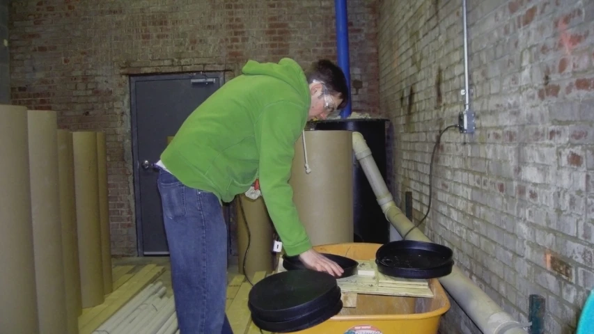 a person bending over a pile of hats