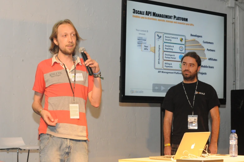 two men in front of a projector screen