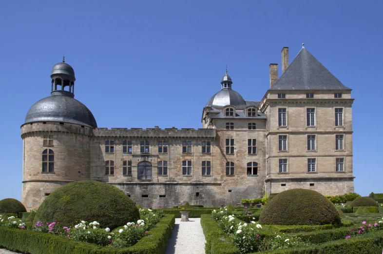 large stone building with garden in front of it