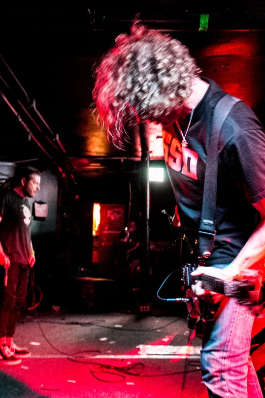 two guys playing instruments in a dark room