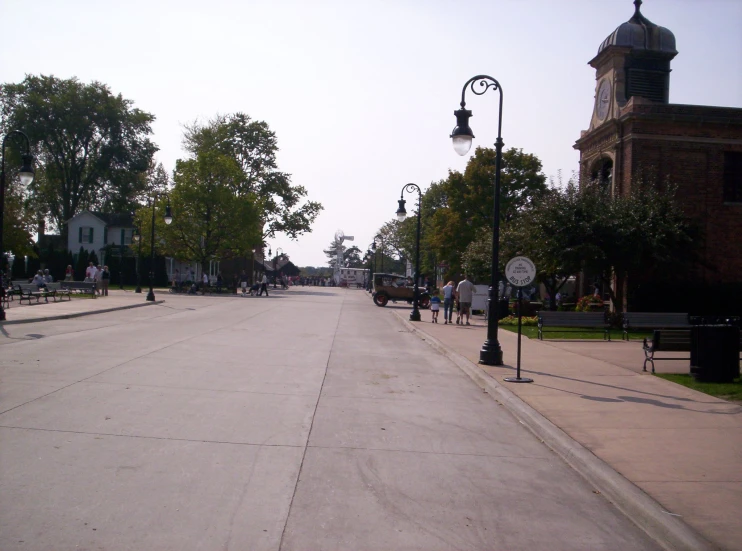 several benches sit on a sidewalk near the street