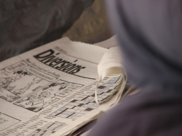 a person's hands are on an article of news paper