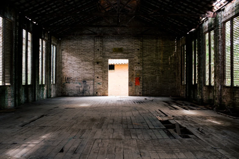 an abandoned building with open shutters and sunlight coming through