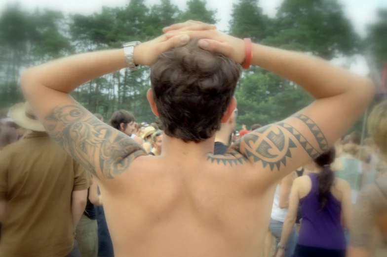 back view of a man wearing tattoos and piercings