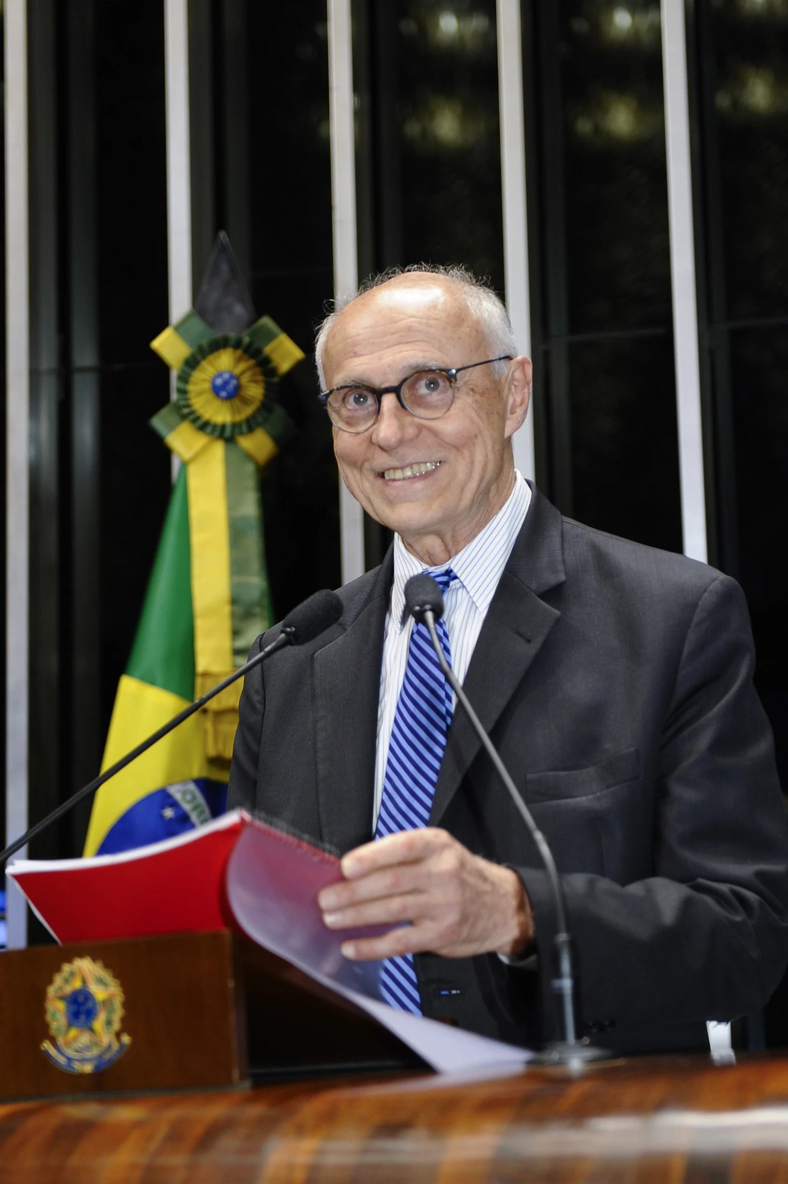 an old man giving a speech while wearing a suite