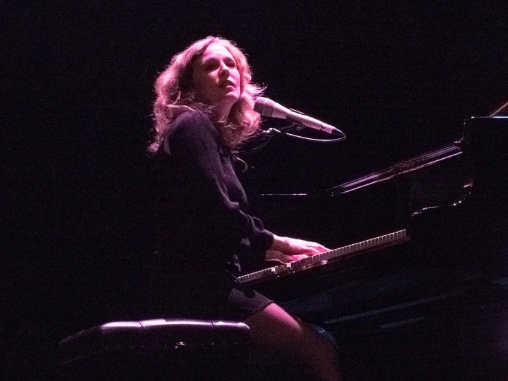 woman standing on stage with an instrument in front of her