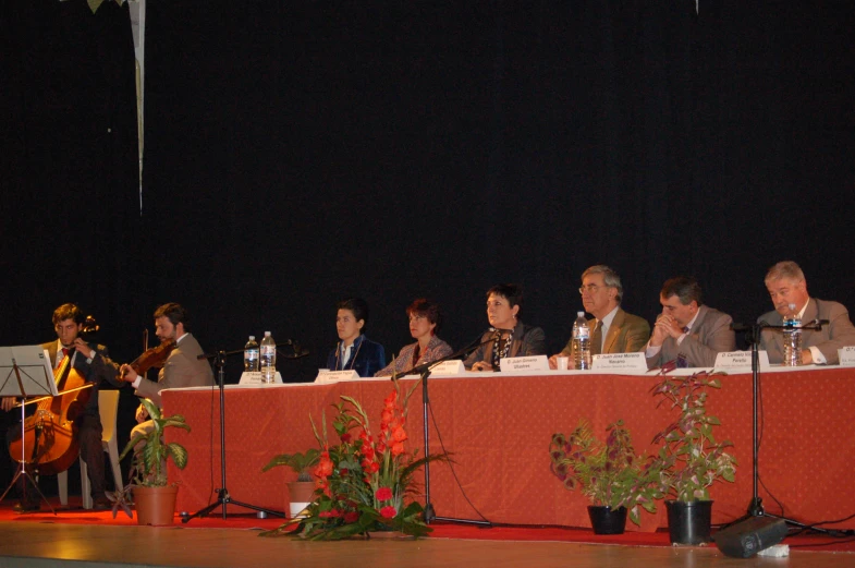 several people at a red and orange table with some microphones