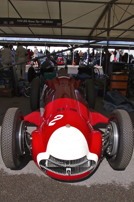 a red sports car is parked under a tent