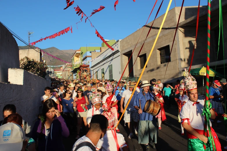 an image of a parade that involves groups of people dressed in costume and carrying flags