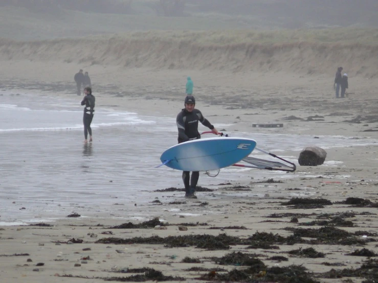 three men on the beach with their surfboards