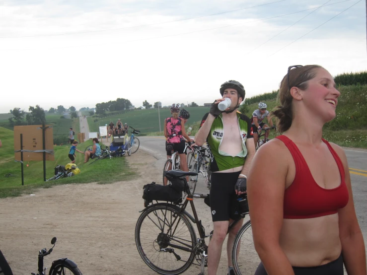 some bicyclists on a dirt road with a lot of people