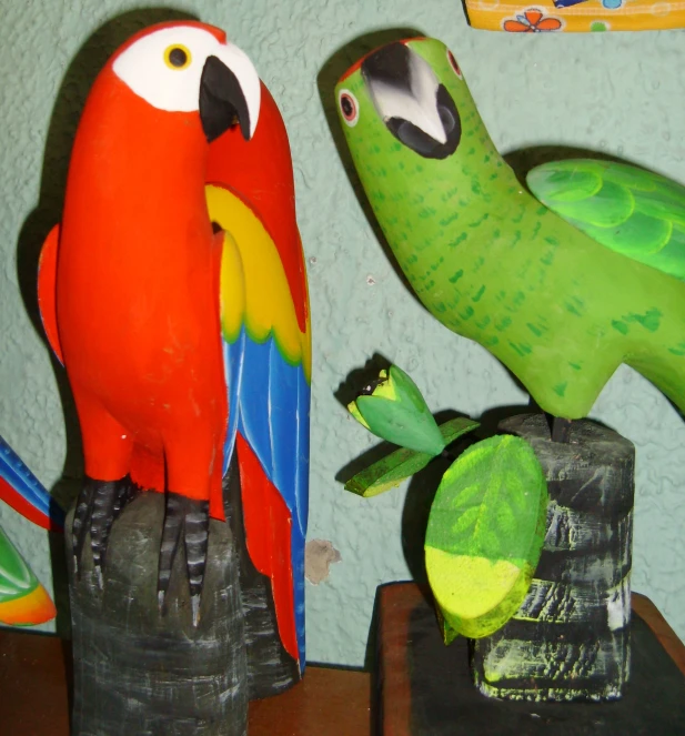 two parrots and an ostrich are perched on top of vases