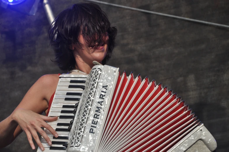 a man holding onto an accordion in front of a light