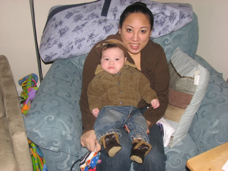 a woman holds a toddler in her lap on a chair