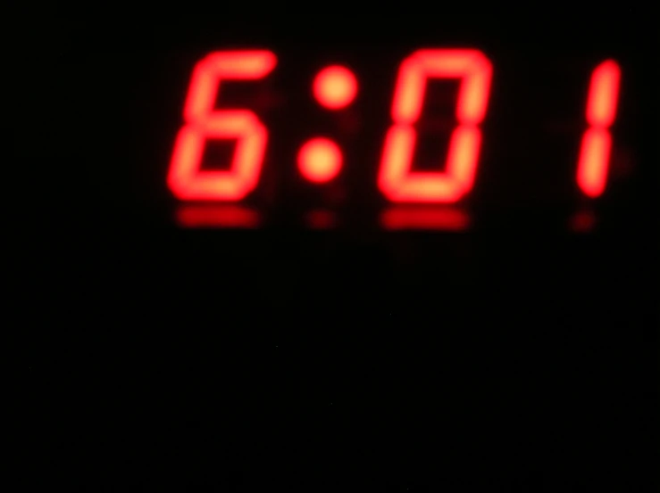 an extreme close up s of a digital clock displaying 6 00