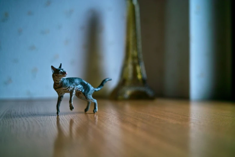 a little toy cat is standing on the floor