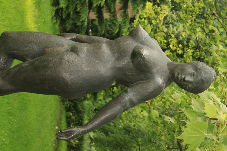 a statue of a  girl sitting in the grass