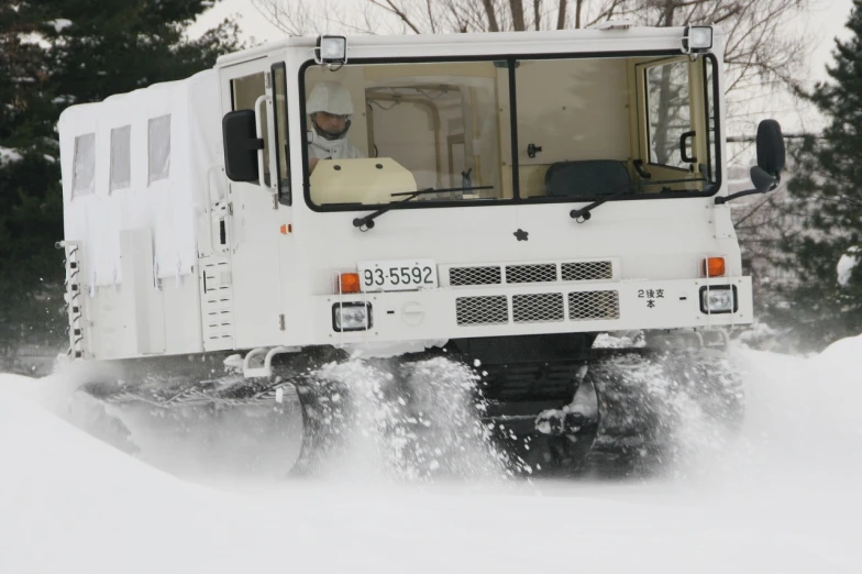 a truck driving through a snow bank covered in snow