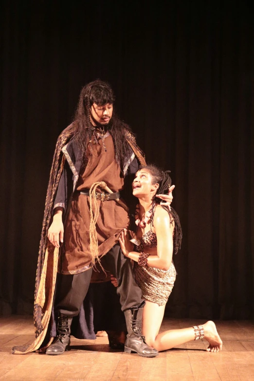 a man and woman in costumes on stage