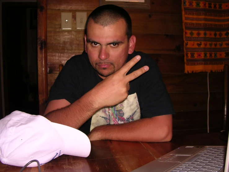 the man is sitting at a table with a laptop