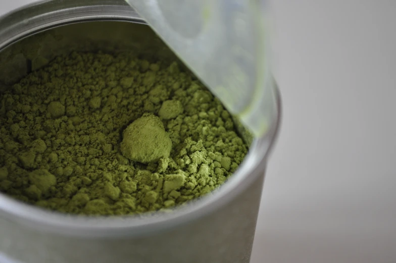 a can filled with green match sitting on a table