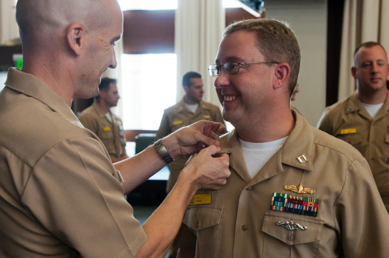 two men in uniform being shown what they have