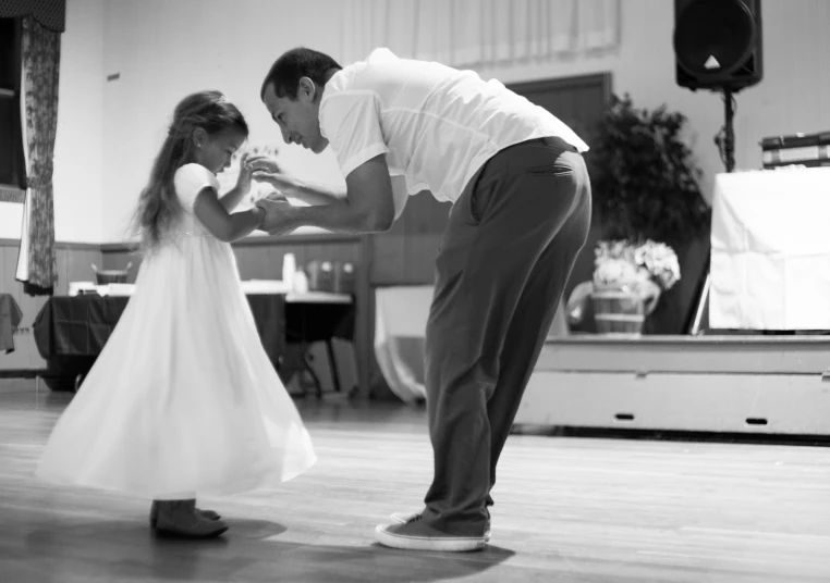 a man is helping a  to walk on the floor